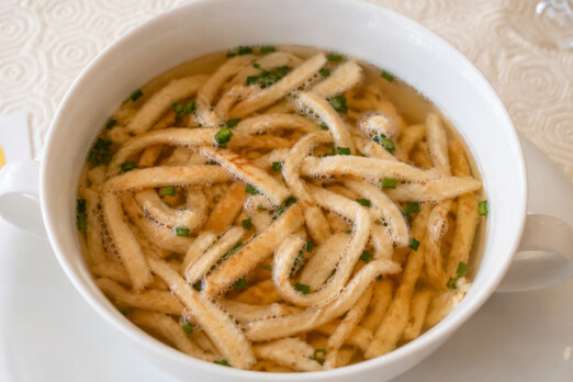 Frische Frittatensuppe in weißer Schüssel mit Schnittlauch serviert bei Mama Rosa Graz